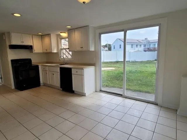 a large kitchen with stainless steel appliances granite countertop a refrigerator and a sink