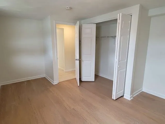 an empty room with closet and wooden floor