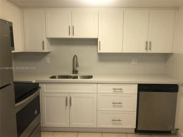 a kitchen with white cabinets and a sink