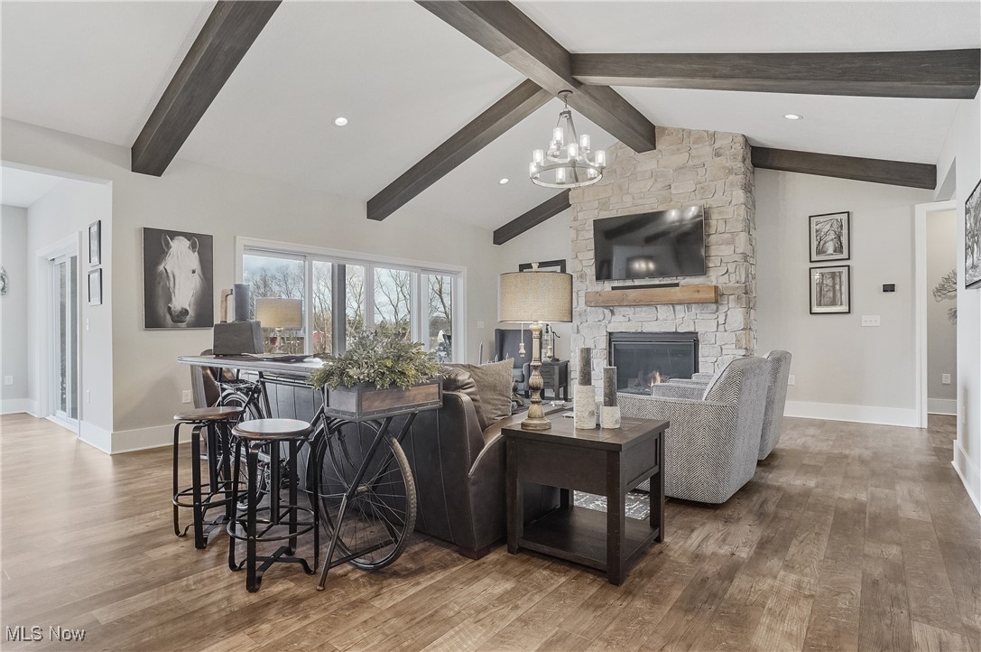 4437 Beach Road Medina, OH 44256 - Photo 10 of 50 Living room featuring vaulted ceiling with beams, hardwood / wood-style floors, a notable chandelier, and a fireplace