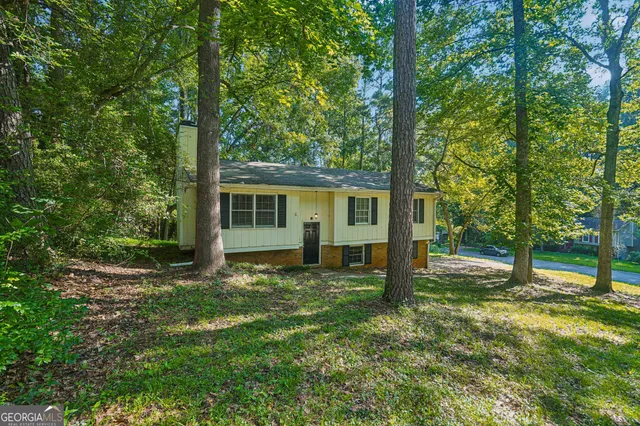 a view of a house with backyard and a tree