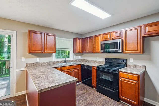 a kitchen with stainless steel appliances granite countertop a sink stove and microwave