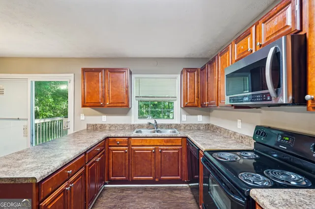 a kitchen with stainless steel appliances granite countertop a stove a sink and a microwave