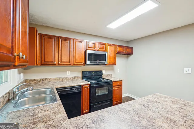 a kitchen with stainless steel appliances granite countertop a stove sink and microwave