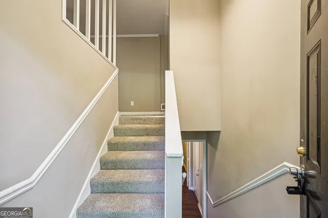 a view of staircase with white walls and a window