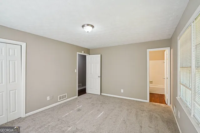 an empty room with windows and closet
