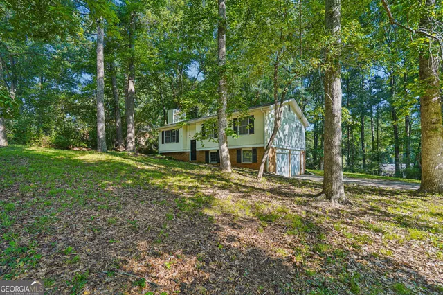 a view of a house with backyard and trees