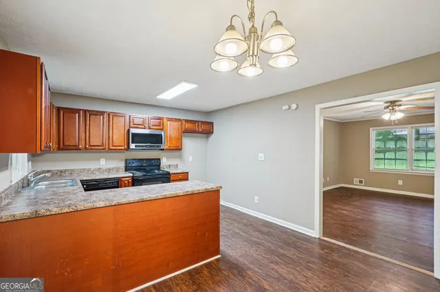 a kitchen with stainless steel appliances granite countertop a sink window and wooden floor