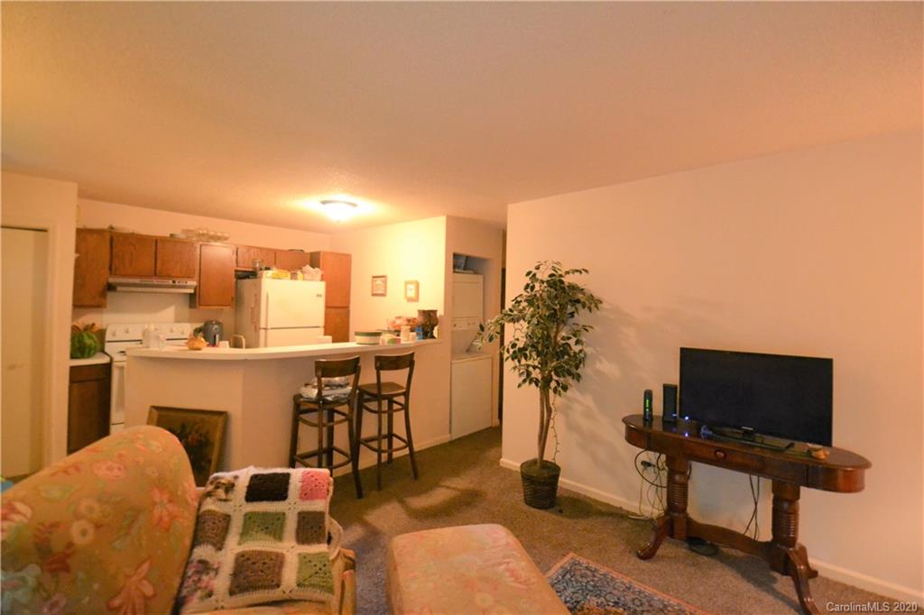 2343 Roland Drive, Unit C Monroe, NC 28110 - Photo 8 of 15 a living room with furniture a flat screen tv and kitchen view