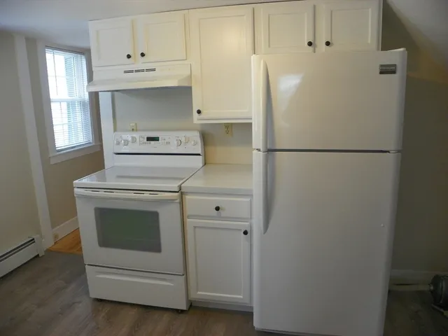 a white refrigerator freezer and a stove sitting inside of a kitchen