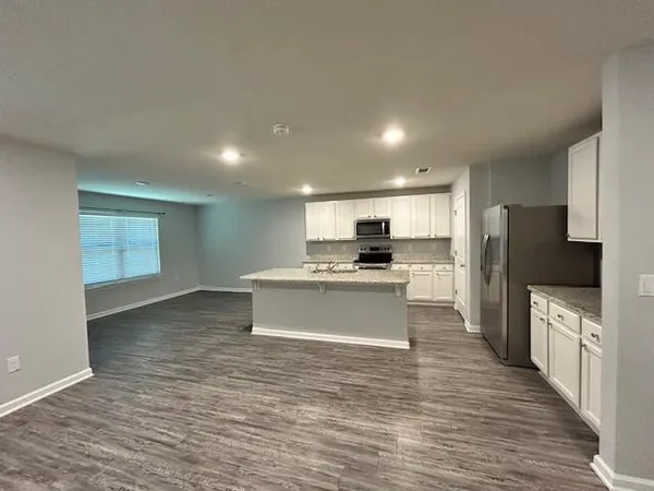 a kitchen with granite countertop white cabinets and stainless steel appliances