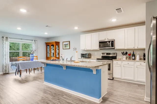 a kitchen with appliances a sink a counter top space and cabinets