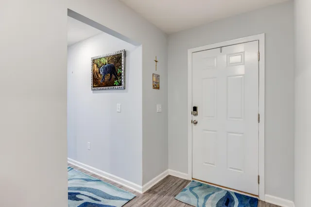 a view of a hallway with wooden floor and closet