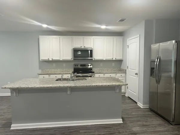 a kitchen with granite countertop cabinets a sink and dishwasher stove