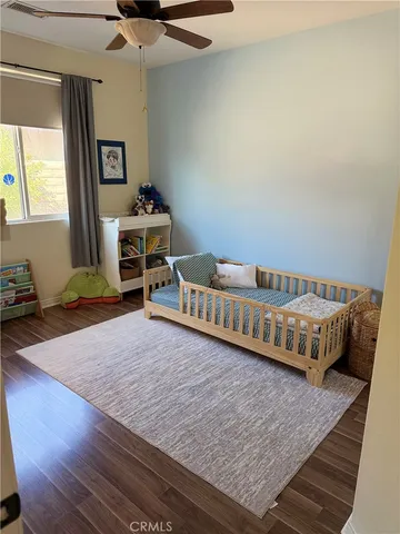 a bedroom with a bed and a wooden floor