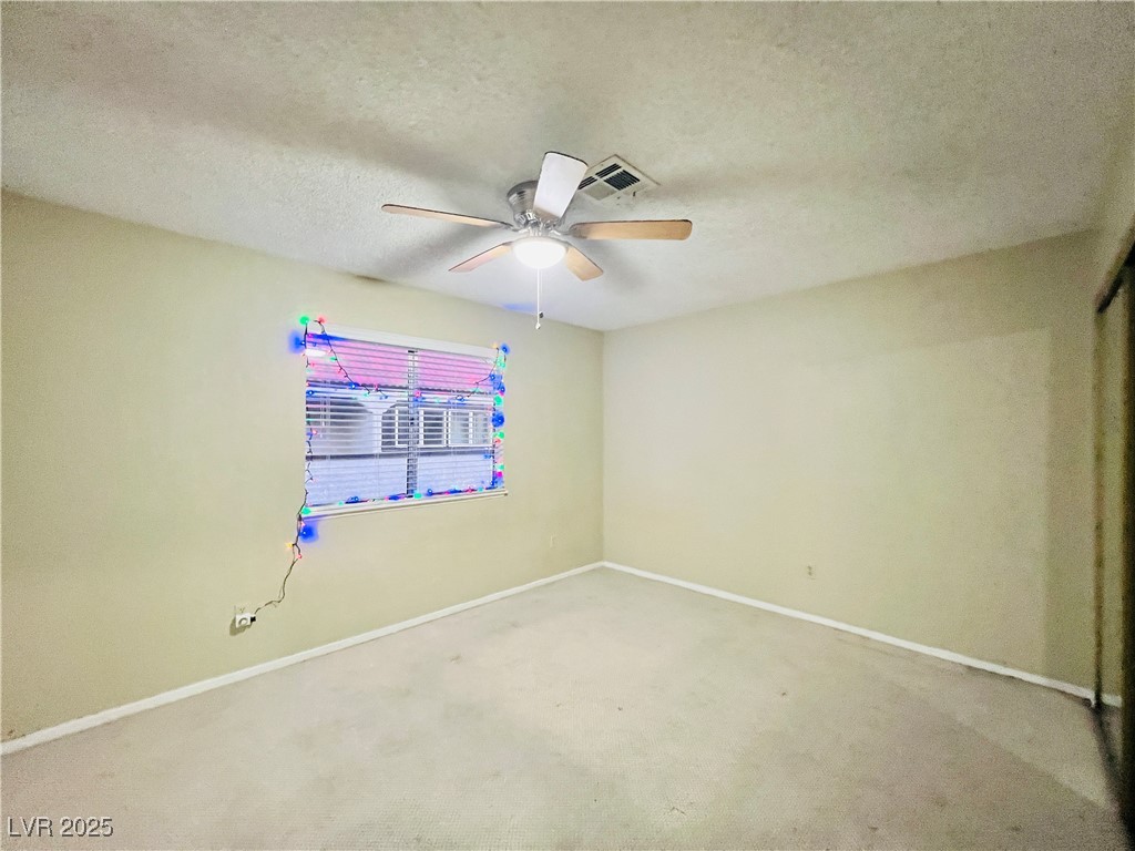 5048 Spencer Street, Unit C Las Vegas, NV 89119 - Photo 14 of 20 Unfurnished room with carpet, a textured ceiling, and ceiling fan