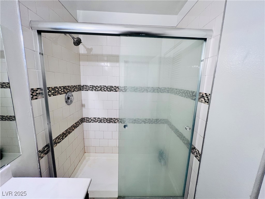 5048 Spencer Street, Unit C Las Vegas, NV 89119 - Photo 18 of 20 Bathroom featuring vanity and a shower stall