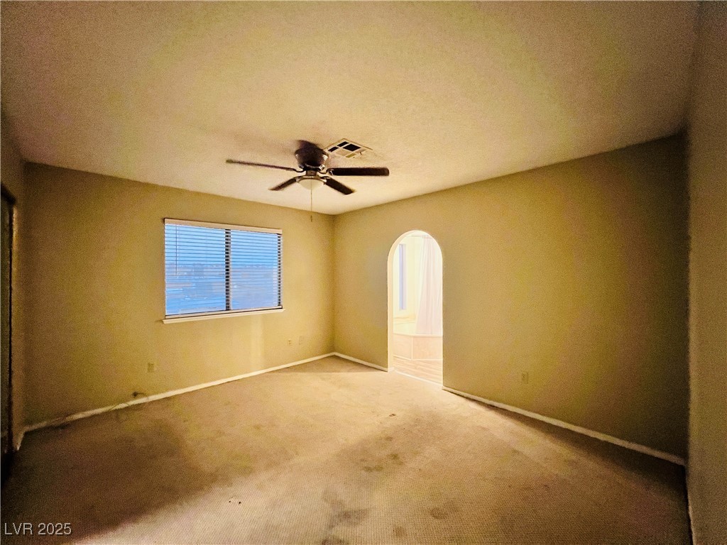 5048 Spencer Street, Unit C Las Vegas, NV 89119 - Photo 5 of 20 Unfurnished bedroom with ceiling fan, carpet floors, and arched walkways