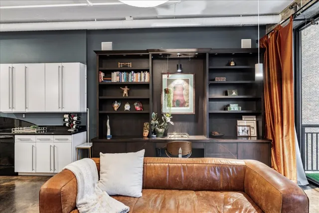 a view of a workspace with furniture and a window