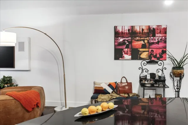 a living room with furniture kitchen view and a large window