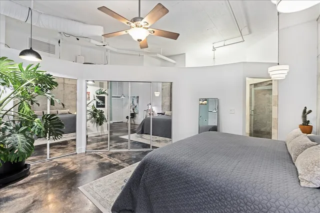 a bedroom with a bed table and a mirror