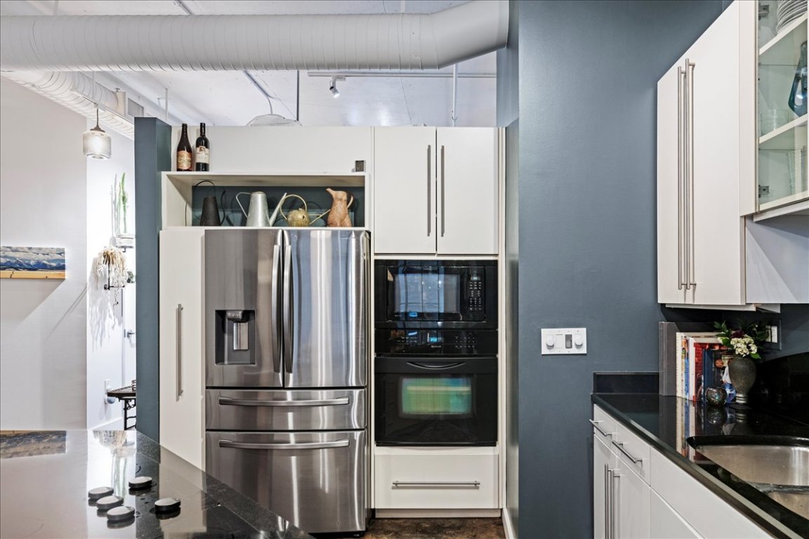 311 West 5th Street, Unit 1008 Austin, TX 78701 - Photo 3 of 31 a kitchen with stainless steel appliances granite countertop a refrigerator and a sink