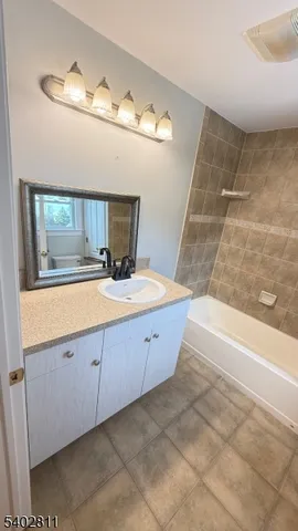 a bathroom with a tub sink and mirror