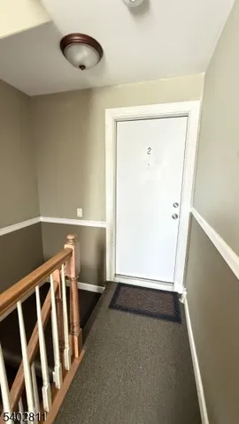 a view of an empty room with wooden floor and windows