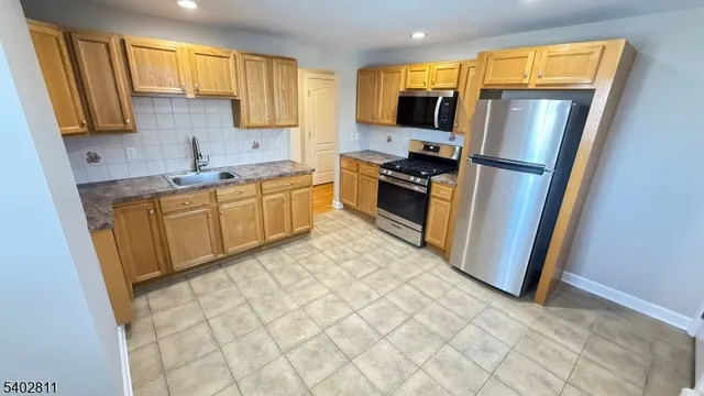 a kitchen with stainless steel appliances a refrigerator sink and microwave