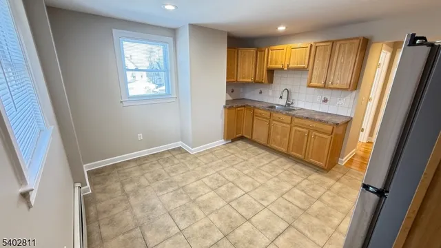 a kitchen with granite countertop a sink refrigerator and cabinets