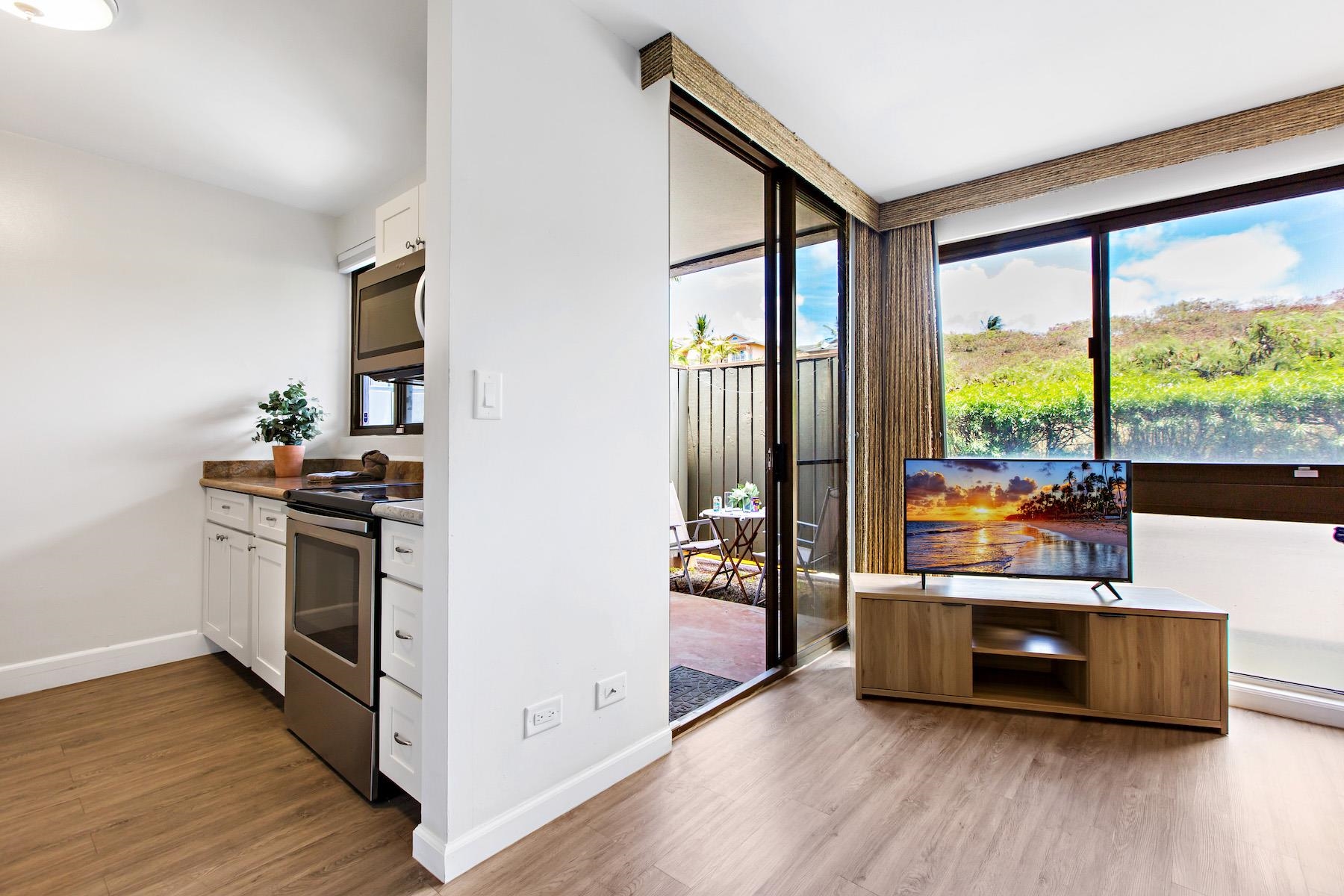 4310 Lower Honoapiilani Road, Unit 218 Lahaina, HI 96761 - Photo 13 of 30 a kitchen with stainless steel appliances a stove and a large window