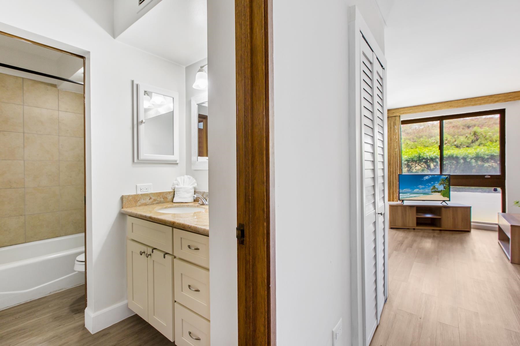 4310 Lower Honoapiilani Road, Unit 218 Lahaina, HI 96761 - Photo 14 of 30 a spacious bathroom with a granite countertop sink a mirror and a bathtub