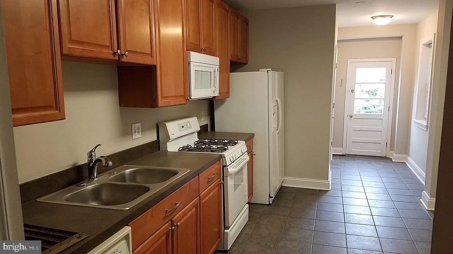 1128 South Hanover Street Baltimore, MD 21230 - Photo 22 of 26 a kitchen with a sink stove and refrigerator