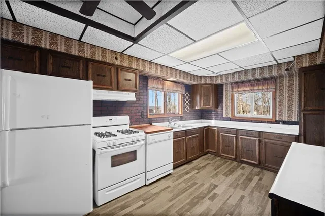 a kitchen with a stove a refrigerator and wooden floor