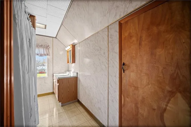 a bathroom with a granite countertop sink a mirror and a shower