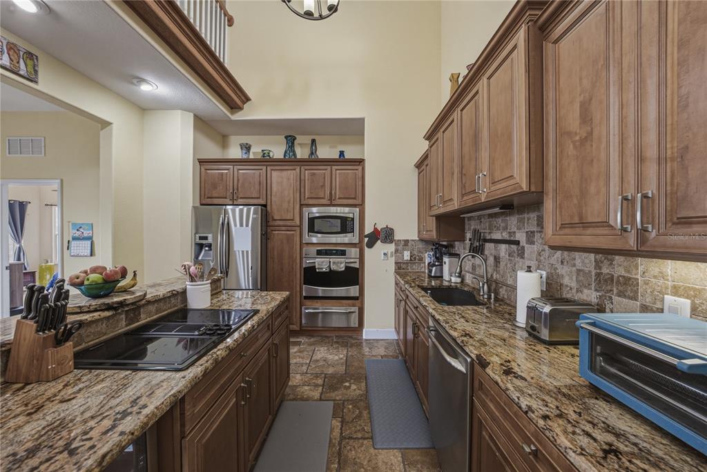 4178 Des Prez Court Hernando Beach, FL 34607 - Photo 18 of 76 a kitchen with stainless steel appliances granite countertop a stove top oven a sink dishwasher and a refrigerator