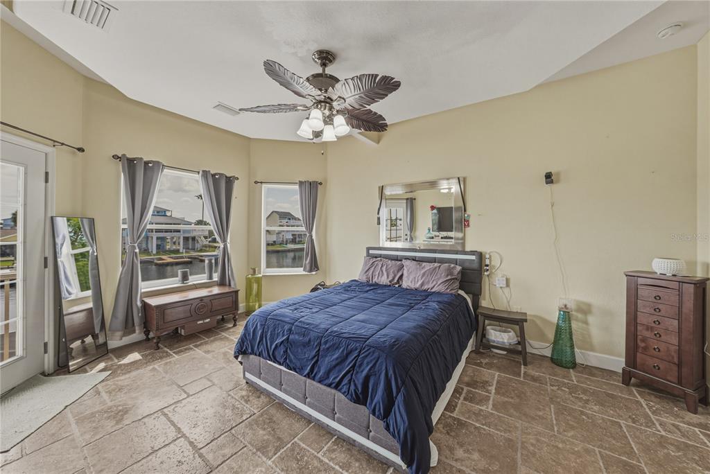 4178 Des Prez Court Hernando Beach, FL 34607 - Photo 27 of 76 a bedroom with a large bed a chandelier and dresser