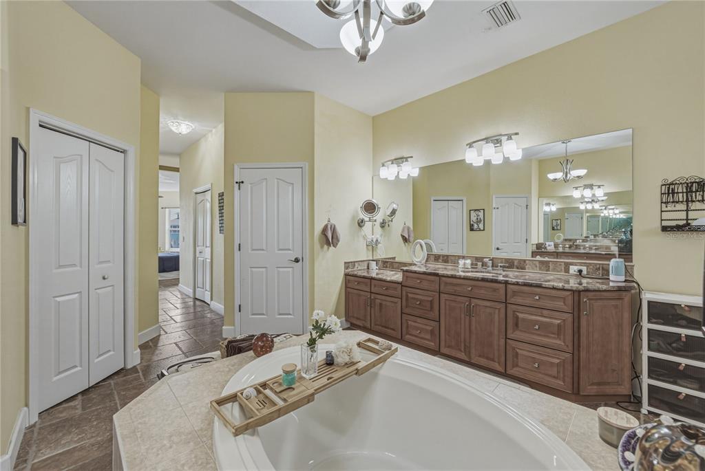 4178 Des Prez Court Hernando Beach, FL 34607 - Photo 34 of 76 a spacious bathroom with a granite countertop tub sink and mirror