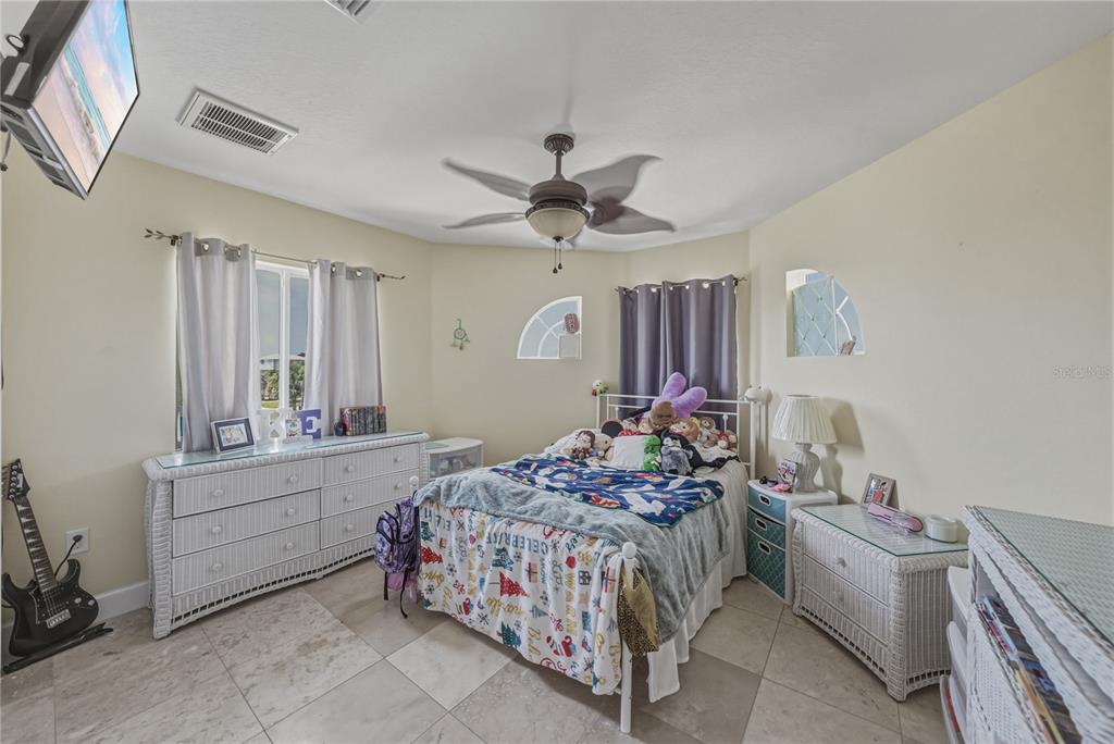 4178 Des Prez Court Hernando Beach, FL 34607 - Photo 38 of 76 a bedroom with a bed and a chandelier