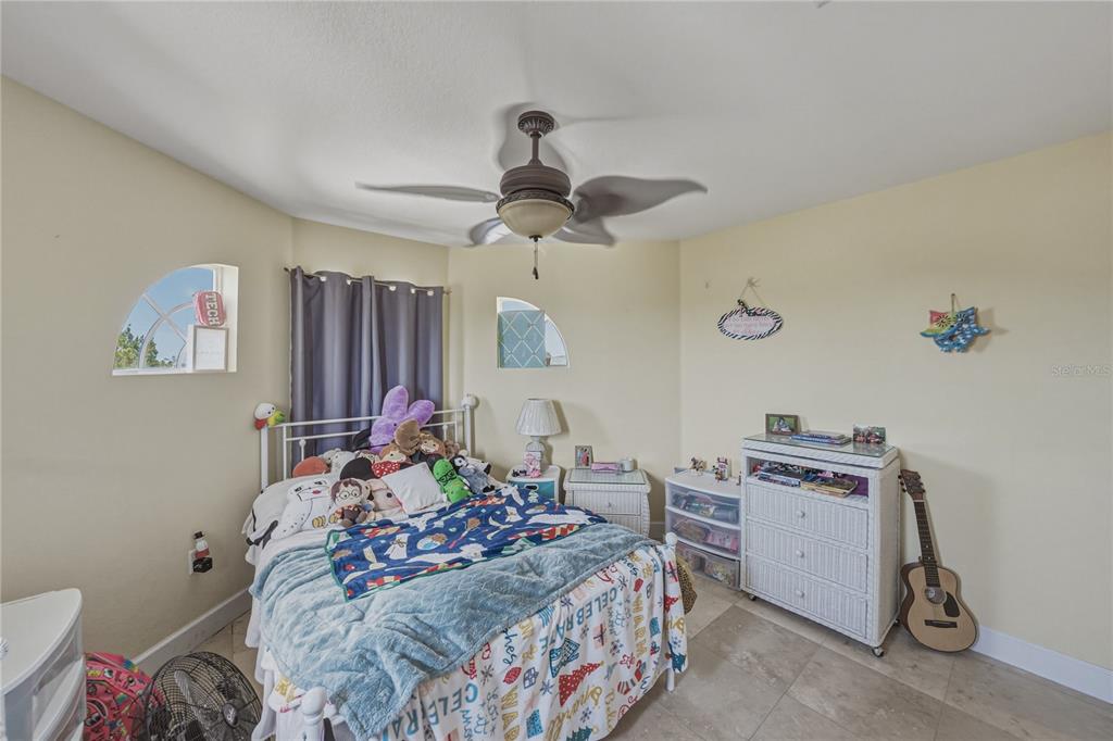 4178 Des Prez Court Hernando Beach, FL 34607 - Photo 39 of 76 a bedroom with a bed and a chandelier