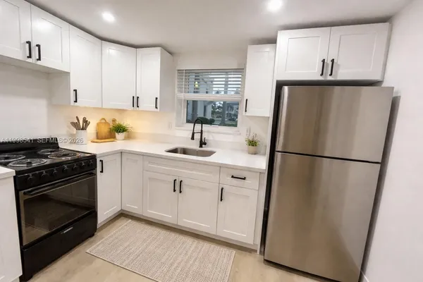 a kitchen with a refrigerator sink stove and cabinets