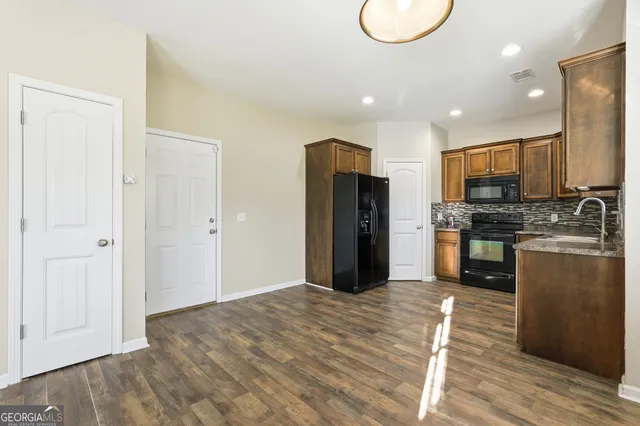 a kitchen with stainless steel appliances granite countertop a refrigerator stove and oven
