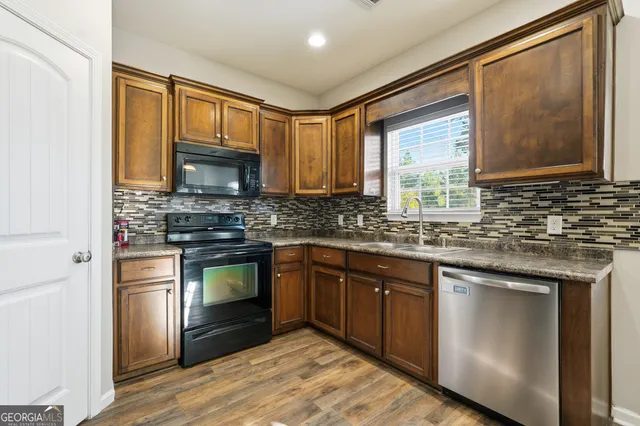 a kitchen with stainless steel appliances granite countertop a stove a sink dishwasher a refrigerator and a microwave oven