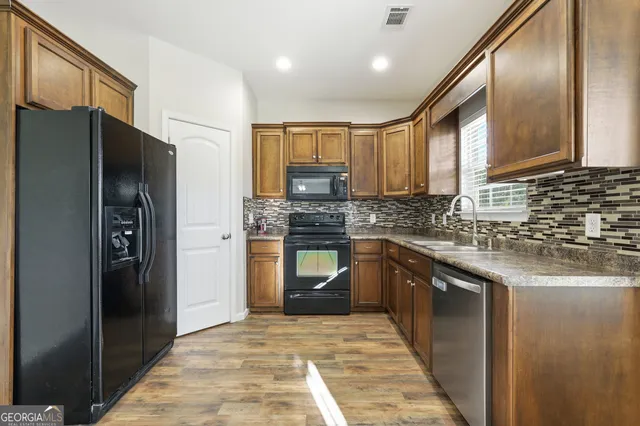 a kitchen with granite countertop stainless steel appliances and refrigerator