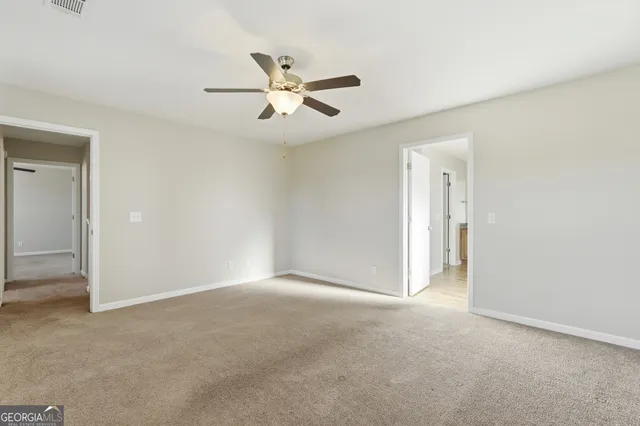 a view of a big room with chandelier fan and windows