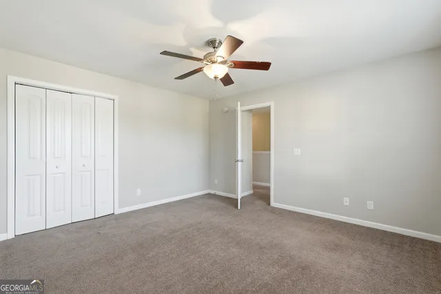 an empty room with closet and windows