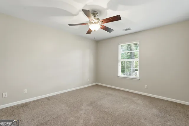 an empty room with window and ceiling fan