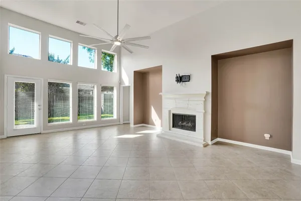an empty room with windows and fireplace