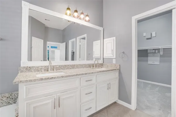 a bathroom with a granite countertop sink double and mirror