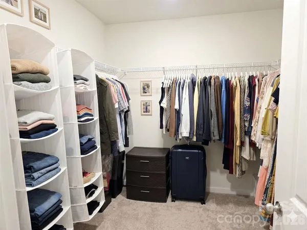 a view of walk in closet with clothes and shoes